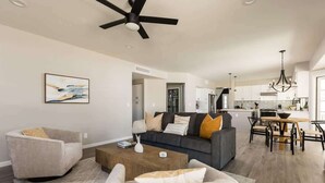 A modern living room with a sofa, armchairs, a coffee table, and a dining area with a table and chairs. - Sereno- North Scottsdale- Private Pool & Games! (Scottsdale)