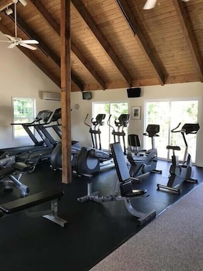 A gym with treadmills, elliptical machines, and weight benches.