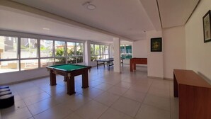 A spacious indoor area with a pool table, a ping pong table, and a foosball table.