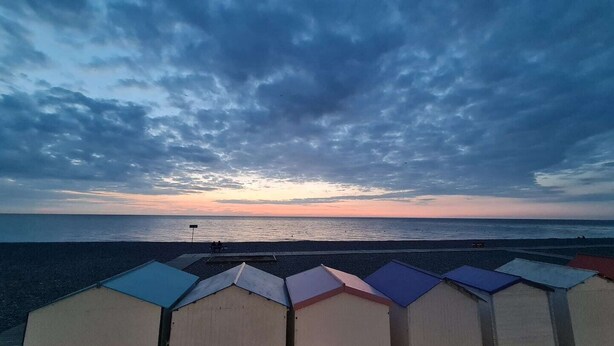 A beach with a row of beach huts and a sunset over the ocean. - Villa 1900 "Jeanne", fully renovated, 100 meters from the beach (Le Tréport)