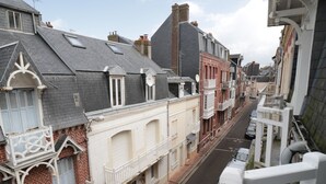 A narrow street lined with historic buildings, featuring balconies and traditional architecture. - Villa 1900 "Jeanne", fully renovated, 100 meters from the beach (Le Tréport)
