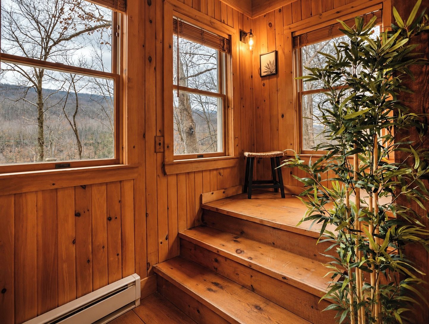 Un interior de madera con ventanas amplias, un banco y una escalera.