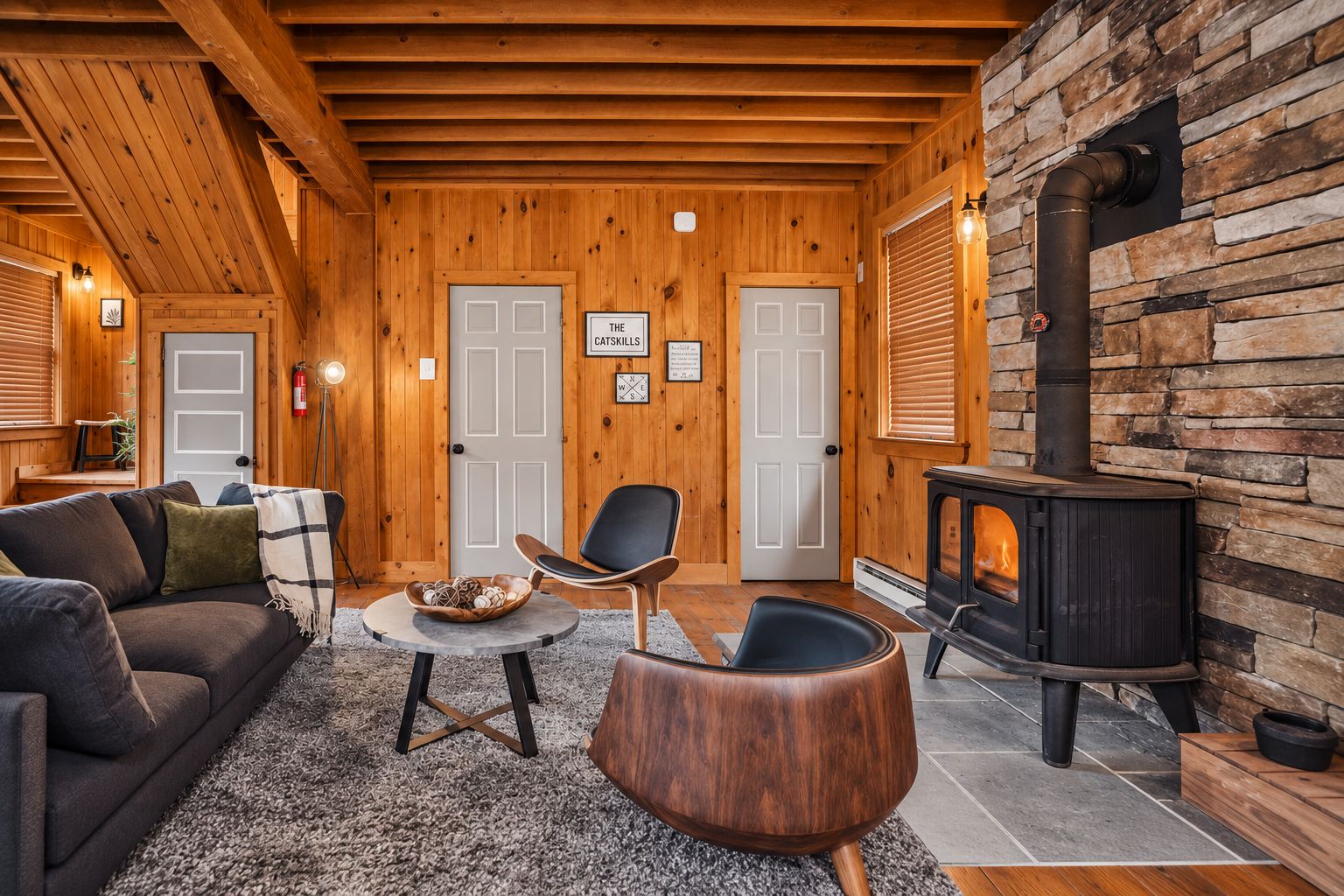 A cozy cabin interior with a fireplace, wooden walls, and a comfortable seating area.
