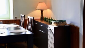 Ein Essbereich mit Tisch, Stühlen, einer Lampe und Dekoration auf einer Theke.