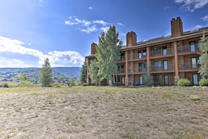 A multi-story building with a flat roof, large windows, and a grassy courtyard.
