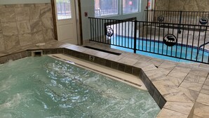 Un área de spa con una bañera de hidromasaje, una piscina y una escalera que lleva a una terraza.