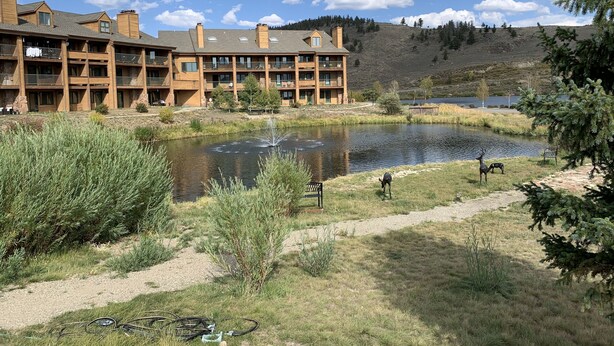 Una cabaña con varios balcones con vistas a un lago, rodeada de paisajes naturales.
