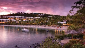 Une station balnéaire dotée de villas en bord de mer, d’une mer calme et de bateaux.