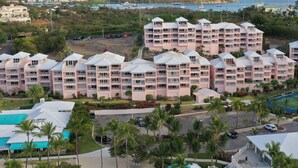 Un hôtel à plusieurs étages, doté de balcons, d’une piscine et d’une marina en arrière-plan.