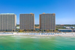 A beachfront hotel with multiple high-rise buildings, a sandy beach, and clear blue waters. - Splash Kids Paradise 17th floor is clean, spacious plus free daily beach service (Panama City Beach)