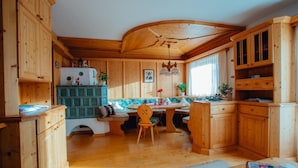 Interior de una cabaña de madera con cocina, comedor y zona de estar.