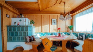 Interior acogedor de una cabaña con una mesa de comedor de madera, asientos tipo banco y un armario empotrado.