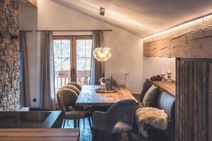 A dining area with a wooden table, chairs, and a hanging light fixture. - Alpine chic in Haus Hahn, combined with modern elegance Chalet Seefelder Spitze by MoniCare (Seefeld in Tirol)