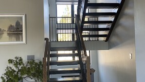 Eine Treppe mit Holzboden und Metallgeländern, die zu einer oberen Etage führt.