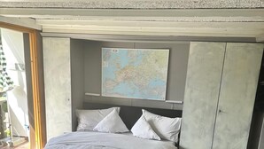 Un dormitorio con cama, un mapa en la pared y una mesa con un mapa.