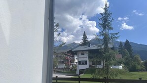 Un edificio blanco con un letrero que dice "Bärenhäusle" en una zona montañosa con árboles y cielo despejado.