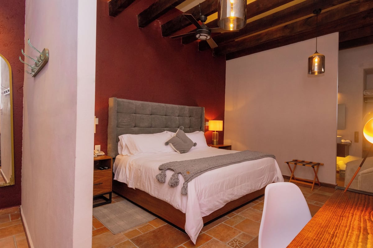 A bedroom with a bed, bedside tables, a lamp, a chair, and a floor lamp.