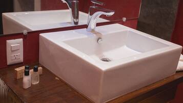 Un baño con un lavabo blanco, un espejo y una encimera de madera.