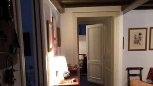 A hallway with wooden flooring, a patterned rug, a sofa, and a door leading to another room. - Fascinating views of Mont Blanc (Courmayeur)