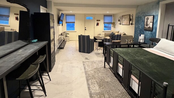 Una cocina moderna con una isla central, electrodomésticos integrados y un área de comedor con sofá y mesa.