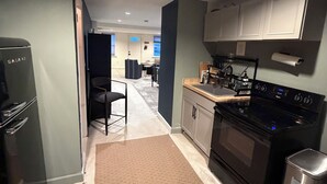 Una cocina compacta con refrigerador, estufa y armarios.