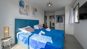 A modern bedroom with a large bed, a wardrobe, and a ceiling light. - Villa U Cousiu (Sainte Lucie De Porto Vecchio)