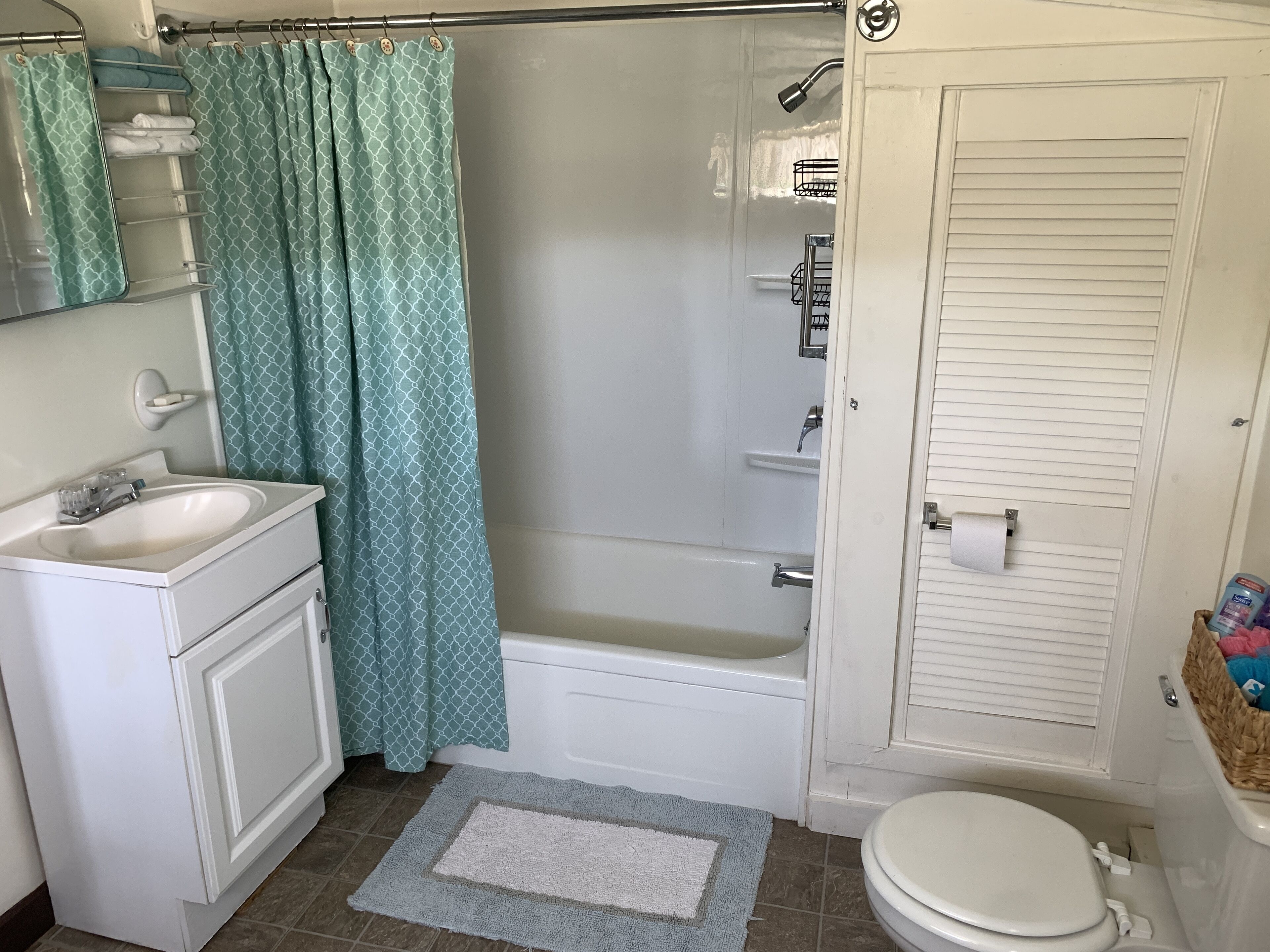 A bathroom with a white sink, a bathtub, a toilet, and a shower.