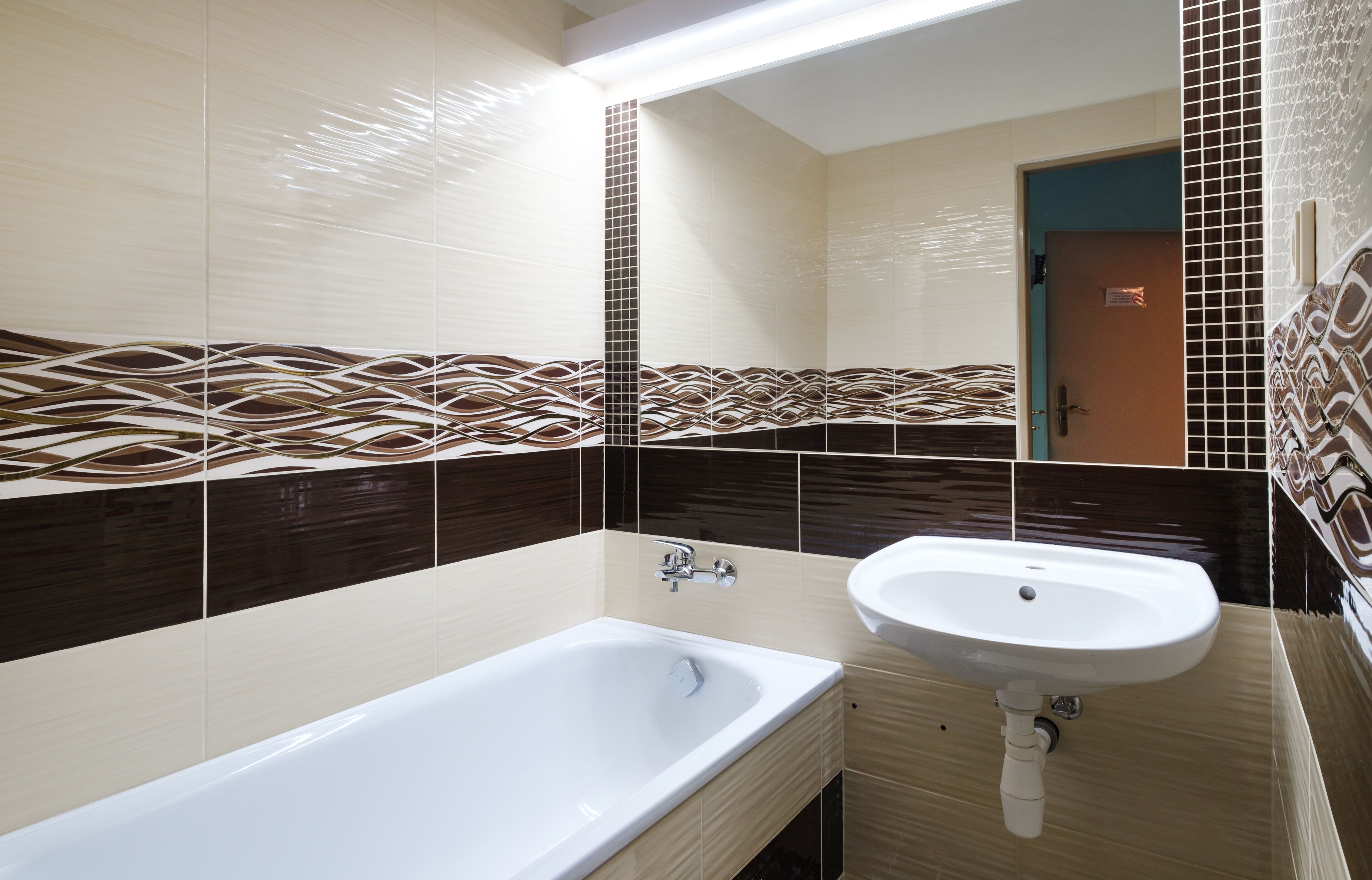 A modern bathroom with a bathtub, a sink, and a mirror.