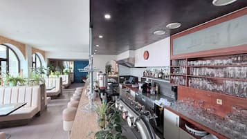 Ein Barbereich mit Sitzgelegenheiten, einer Bar und Regalen mit Gläsern und Flaschen.