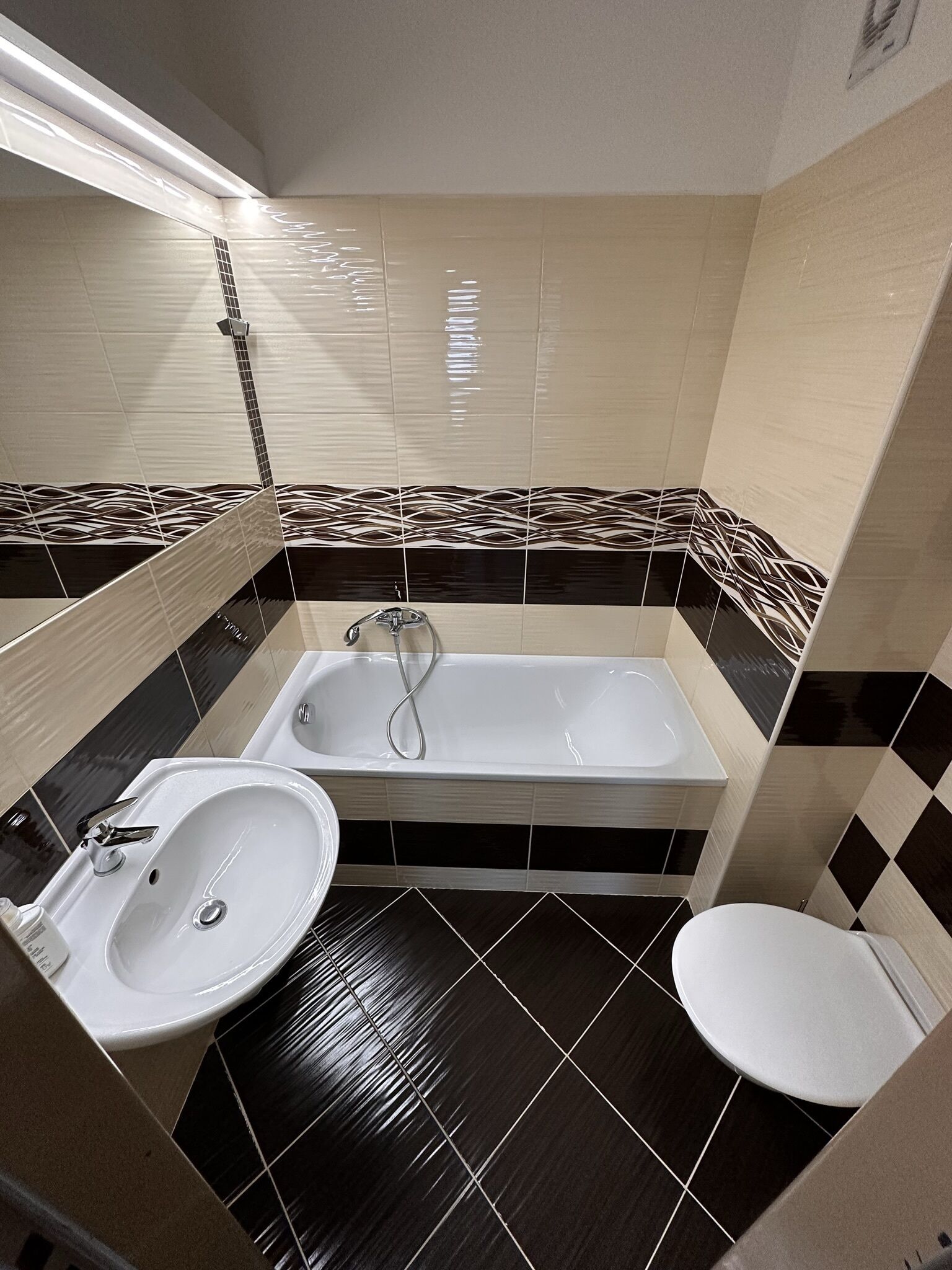 Et badeværelse med badekar, vask og toilet.