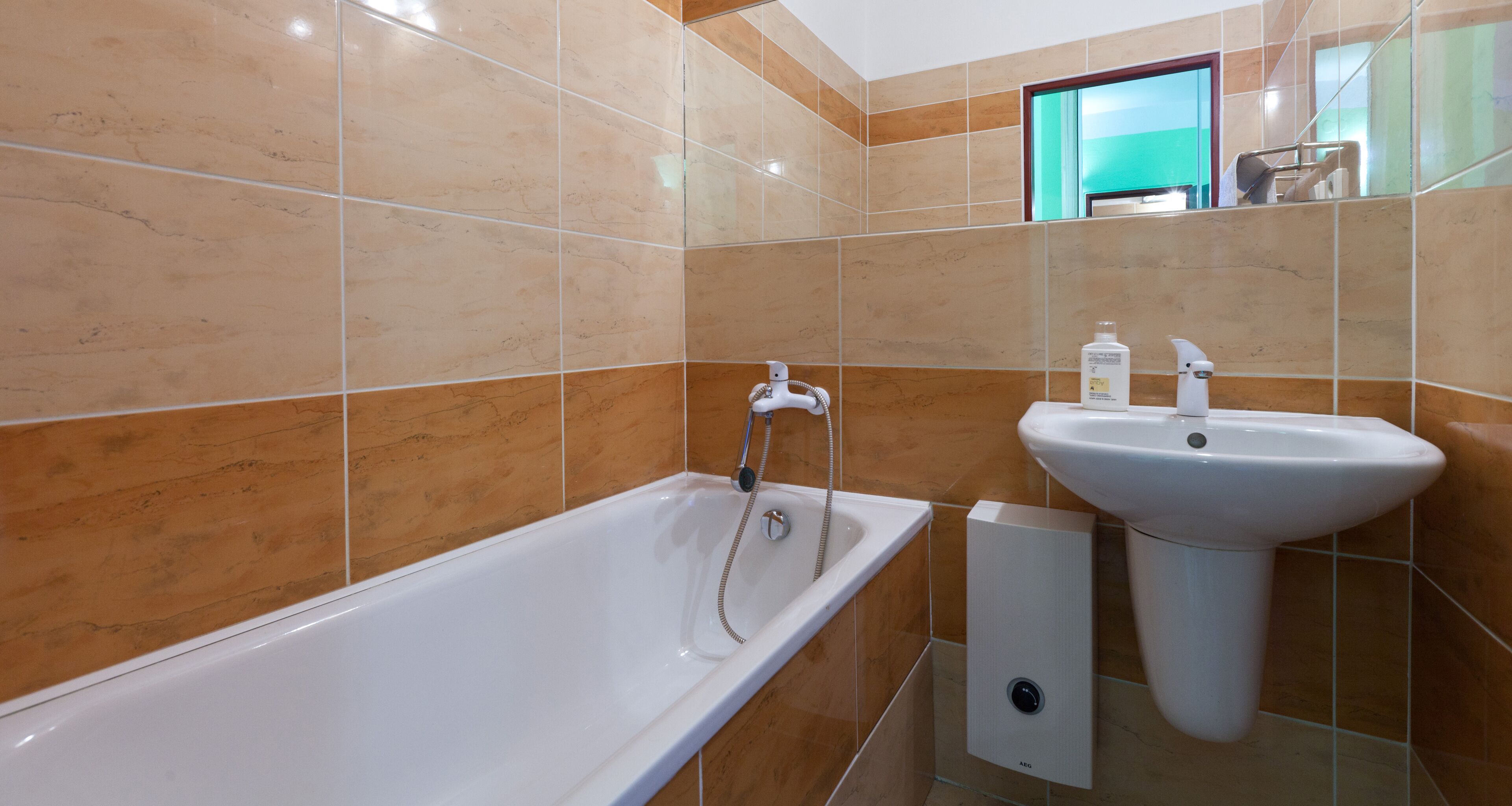 Un baño moderno con una bañera blanca, un lavabo y un espejo.