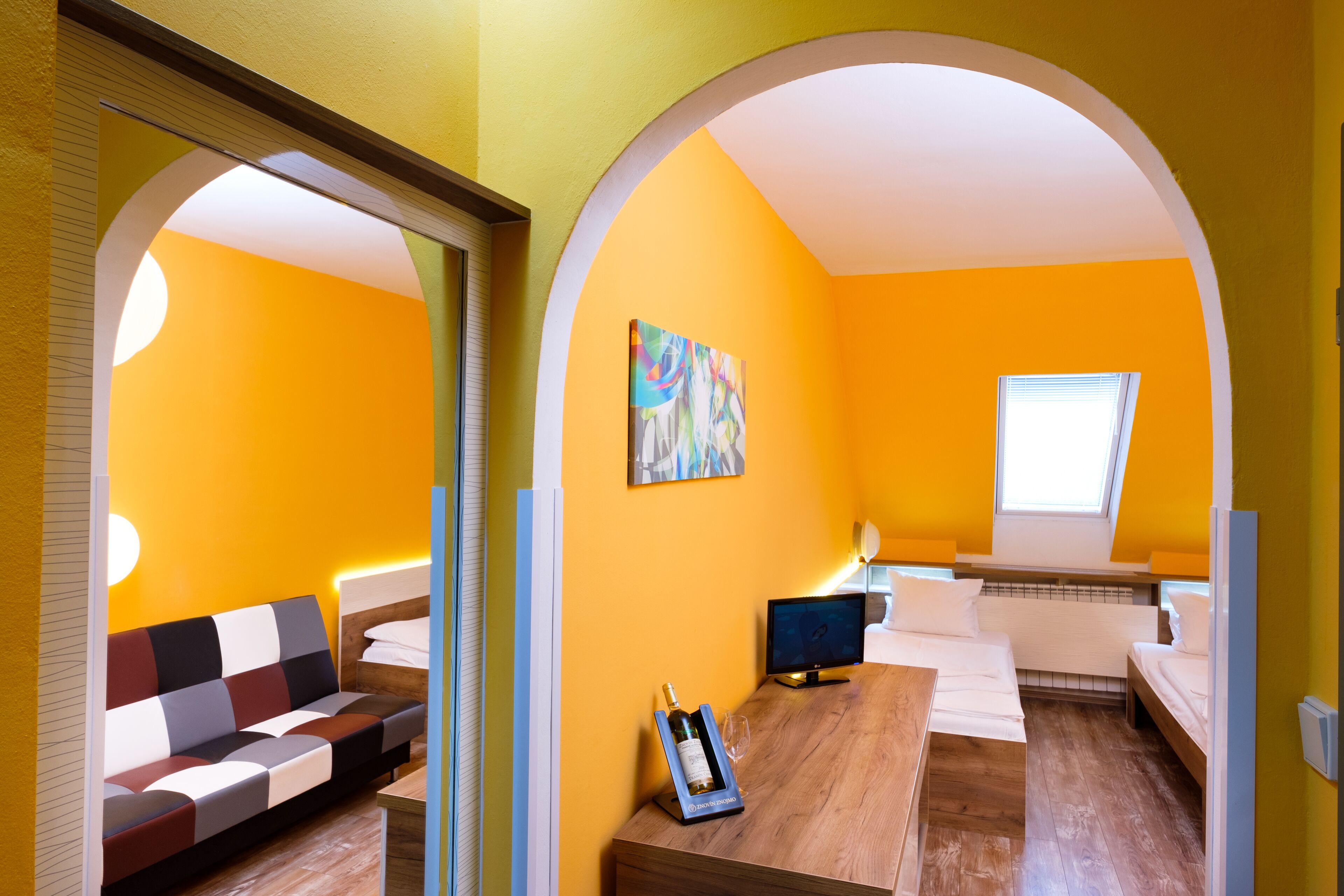 Una habitación con sofá, una mesa de madera, un televisor y un cuadro en la pared.