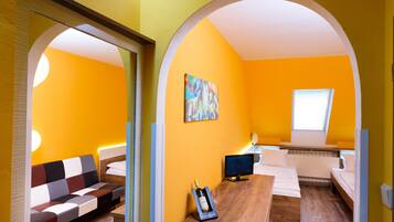 Una habitación con sofá, una mesa de madera, un televisor y un cuadro en la pared.