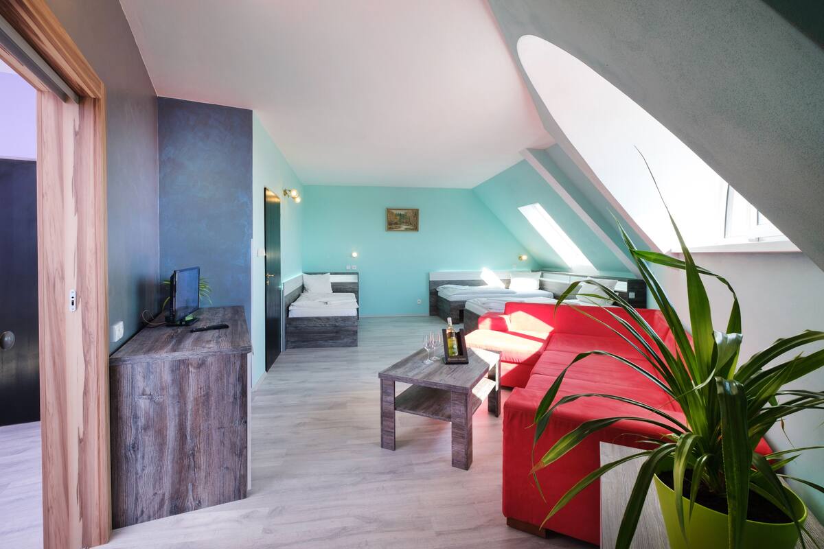 Un intérieur avec un canapé rouge, une table basse en bois et une plante verte.