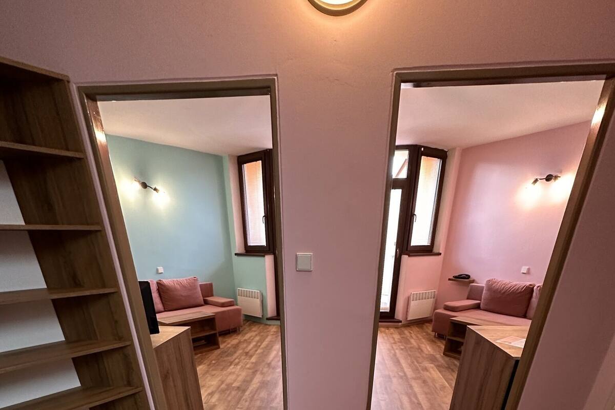 Une pièce dotée d’un plancher en bois, d’une banquette intégrée et d’un luminaire fixé au mur.