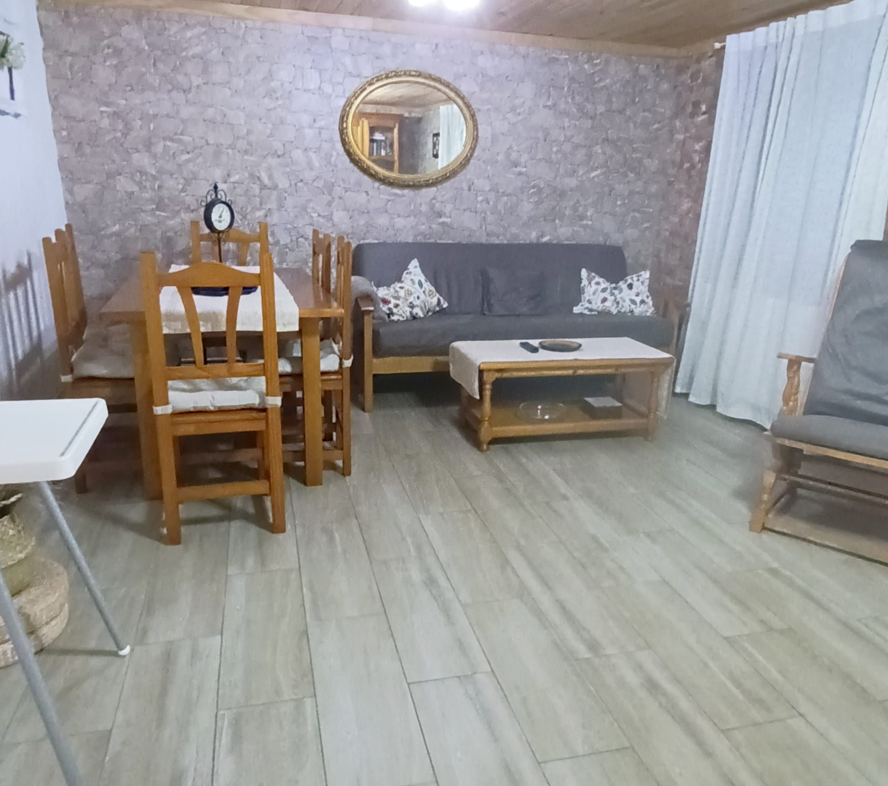Ein Wohnzimmer mit Esstisch, Stühlen, einer Couch und einem Couchtisch.