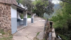 A stone building with a stone and concrete pathway leading to a covered area. - La Caseta Rural House (La Casa De La Noguera)