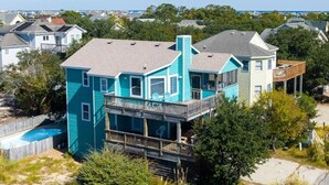 A two-story house with a balcony and a swimming pool. - Short walk to Beach with Pool, Game Room, and Spa! (Corolla)