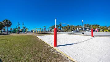 Enjoy a game of volleyball or explore the playground surrounded by lush palm trees.