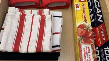 A drawer containing a red cap, a striped towel, and several boxes of pasta.