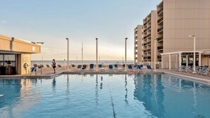 A swimming pool with lounge chairs and a building with multiple balconies. - π 3BR/3BA π Ground Floor @ Pinnacle Port βοΈ π 50 π©΄π©΄ to the sand (Panama City Beach)