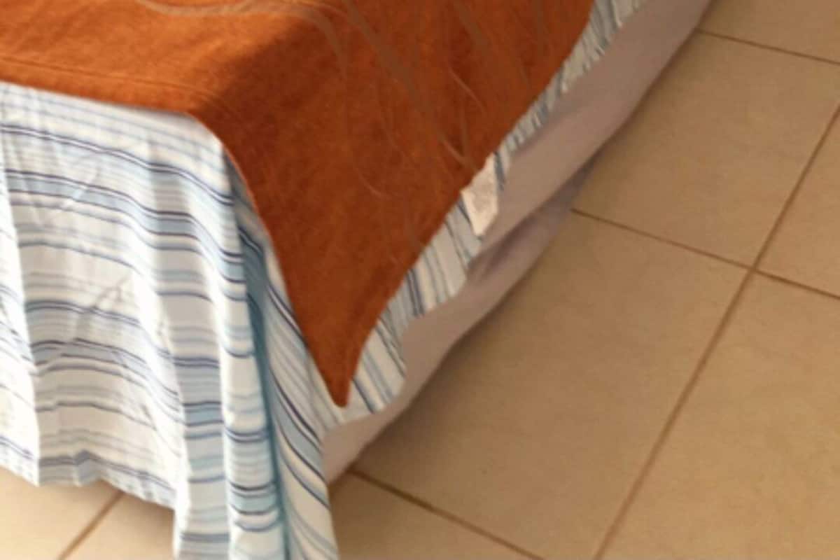 A bed with striped bedding and a single decorative pillow.