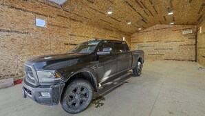 En svart pickup-truck stod parkerad i ett garage med väggar av trä och ett betonggolv.