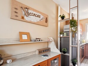 Eine moderne Küche mit Marmorarbeitsplatte, Holzschränken und einem an der Wand befestigten Schild.