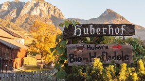 A wooden sign with 'Huber's Bio-Hofladele' and an arrow pointing right, set against a mountainous backdrop. - Traditional vacation apartment in rustic style with view of the Schlern (Völs am Schlern)