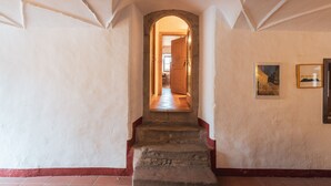 A hallway with a stone staircase leading to a door at the end. - Traditional vacation apartment in rustic style with view of the Schlern (Völs am Schlern)