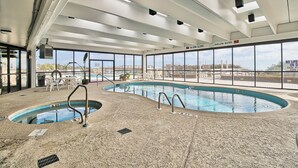 Una piscina interior con señalización clara, tragaluces y vistas al exterior.