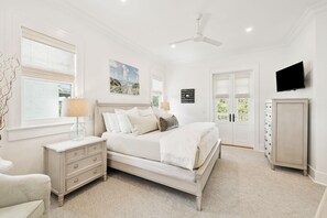 Ein Schlafzimmer mit Bett, Kommode, Fernseher und Bildern an der Wand.