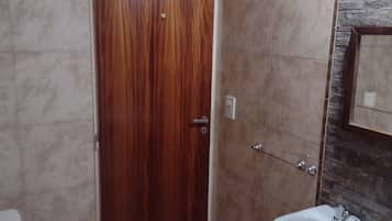 Een bad/douchecombinatie, een bidet, handdoeken, zeep