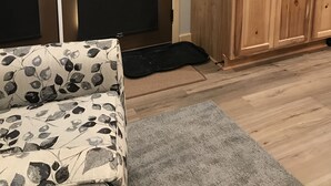 Ein Zimmer mit einem Bett, einem an der Wand montierten Fernseher, Holzschränken und einer Schiebetür.